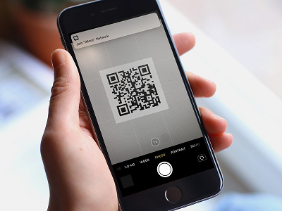 iPhone camera pointed at a QR code, showing a notification to open its link
