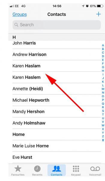 iPhone Contacts list with an arrow pointing to the contact to delete
